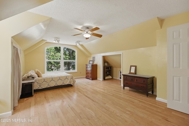 2708 Poinsettia Ave, Middleburg, FL 32068 - bedroom with light wood-style floors, a textured ceiling, lofted ceiling, a ceiling fan, and baseboards