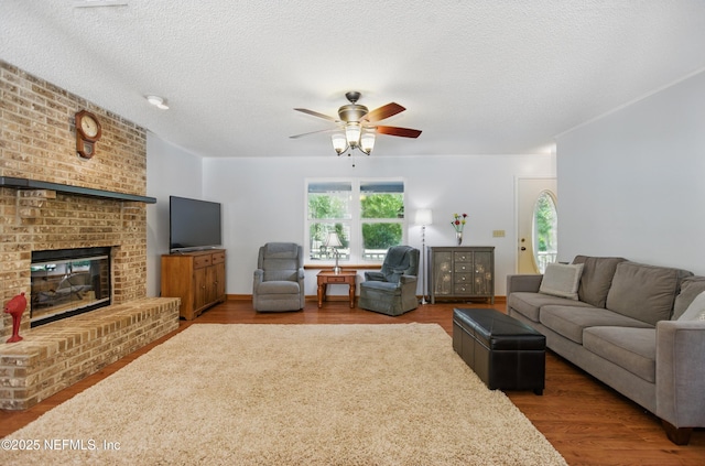 2708 Poinsettia Ave, Middleburg, FL 32068 - living room with ceiling fan, wood finished floors, a fireplace, and a textured ceiling