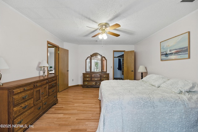 2708 Poinsettia Ave, Middleburg, FL 32068 - bedroom with light wood-type flooring, a textured ceiling, ornamental molding, a spacious closet, and ceiling fan