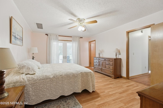 2708 Poinsettia Ave, Middleburg, FL 32068 - bedroom featuring light wood-style floors, a textured ceiling, french doors, ornamental molding, and ceiling fan
