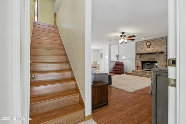 2708 Poinsettia Ave, Middleburg, FL 32068 - stairs featuring a ceiling fan, a fireplace, wood finished floors, and baseboards