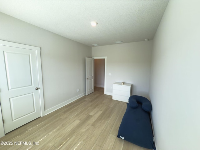 10065 Element Rd, Jacksonville, FL 32256 - unfurnished bedroom with light wood-style floors, a textured ceiling, and baseboards