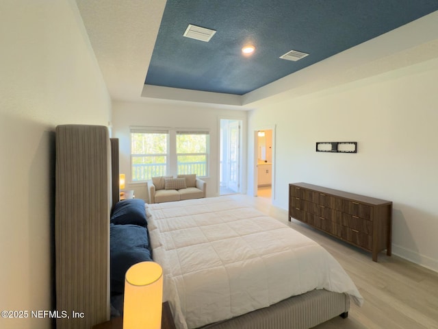 10065 Element Rd, Jacksonville, FL 32256 - bedroom with baseboards, light wood-style floors, a tray ceiling, and recessed lighting