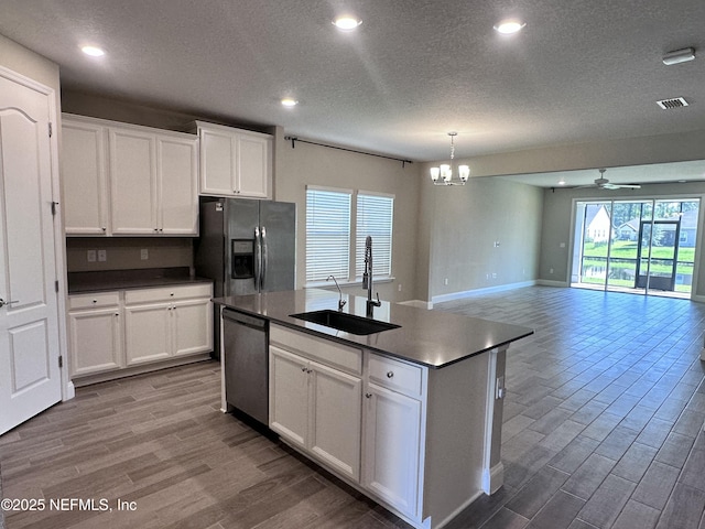 510 Broomsedge Cir, Saint Augustine, FL 32095 - kitchen with a sink, stainless steel appliances, dark countertops, a textured ceiling, and wood finished floors