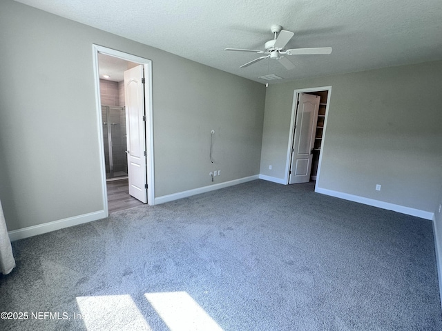 510 Broomsedge Cir, Saint Augustine, FL 32095 - unfurnished bedroom featuring carpet flooring, baseboards, a walk in closet, a textured ceiling, and ceiling fan