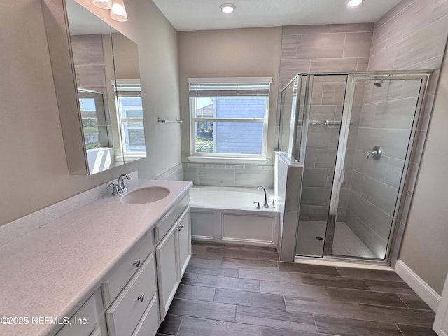 510 Broomsedge Cir, Saint Augustine, FL 32095 - bathroom with vanity, a garden tub, a stall shower, wood tiled floors, and recessed lighting