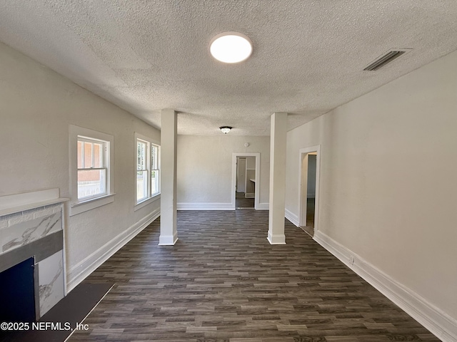 725 Calvert St, Jacksonville, FL 32208 - unfurnished living room with dark wood-type flooring, a textured ceiling, a premium fireplace, and baseboards