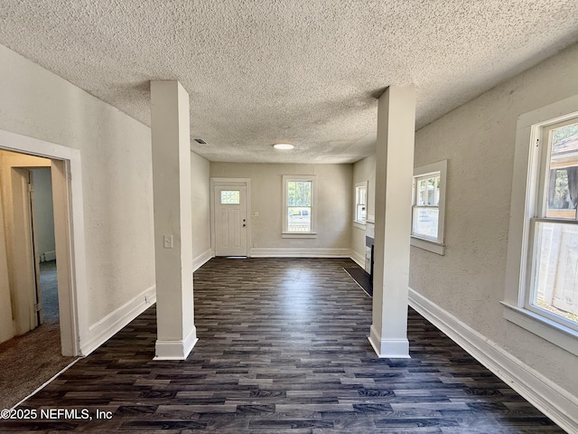 725 Calvert St, Jacksonville, FL 32208 - foyer entrance with a textured ceiling, dark wood-type flooring, a textured wall, and baseboards