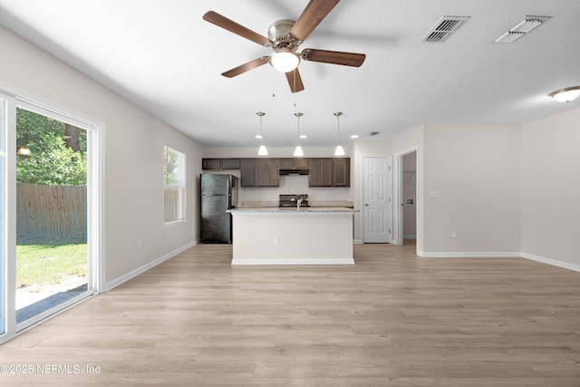 7529 Hare Ave, Jacksonville, FL 32211 - kitchen with freestanding refrigerator, electric stove, light countertops, a center island, and light wood-type flooring
