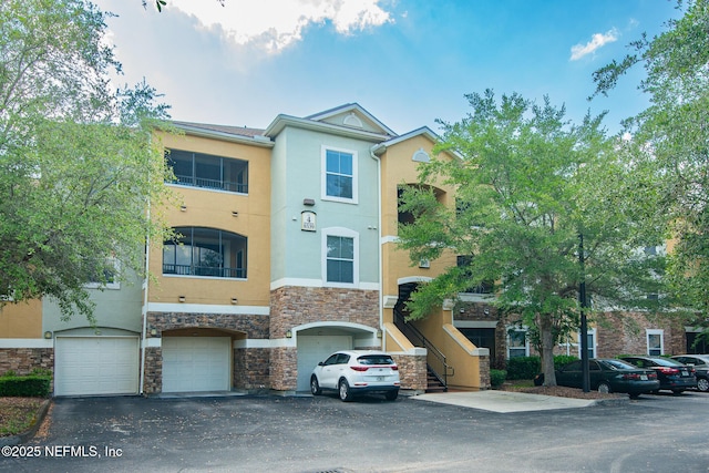 8539 W Gate Pkwy Unit 424, Jacksonville, FL 32216 - view of building exterior with a garage, stairs, and driveway