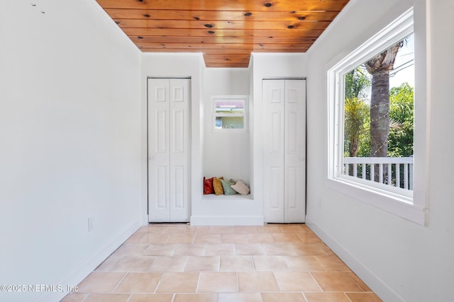 655 Linwood Ave, Jacksonville, FL 32206 - unfurnished bedroom featuring wooden ceiling, two closets, baseboards, and light tile patterned flooring