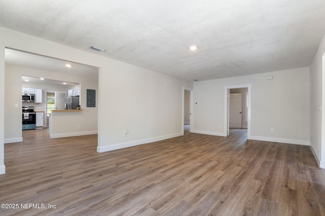 655 Linwood Ave, Jacksonville, FL 32206 - unfurnished living room featuring electric panel, light wood-style floors, recessed lighting, baseboards, and a textured ceiling