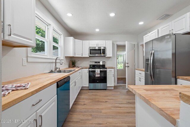 655 Linwood Ave, Jacksonville, FL 32206 - kitchen with stainless steel appliances, wooden counters, a sink, light wood finished floors, and recessed lighting