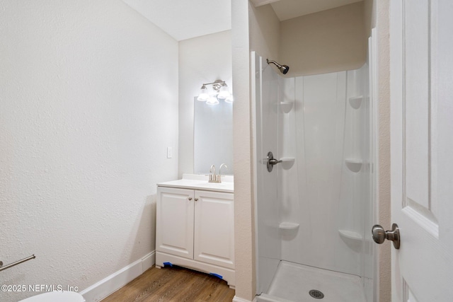 655 Linwood Ave, Jacksonville, FL 32206 - bathroom featuring vanity, wood finished floors, a walk in shower, and baseboards