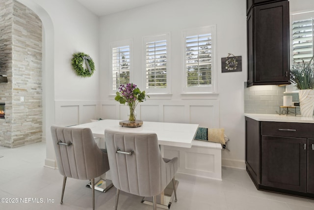 465 Deer Valley Dr, Ponte Vedra, FL 32081 - dining area featuring a decorative wall, arched walkways, a wainscoted wall, and light tile patterned flooring