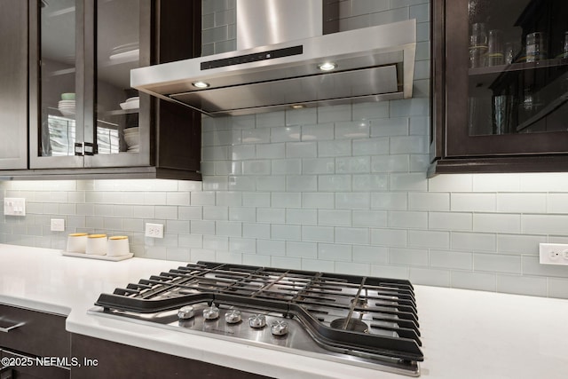 465 Deer Valley Dr, Ponte Vedra, FL 32081 - kitchen with exhaust hood, stainless steel gas cooktop, dark brown cabinetry, light countertops, and glass insert cabinets