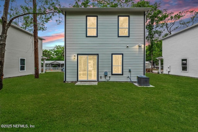 171 Cougar Rd, Jacksonville, FL 32220 - back of house at dusk with a yard and central AC unit