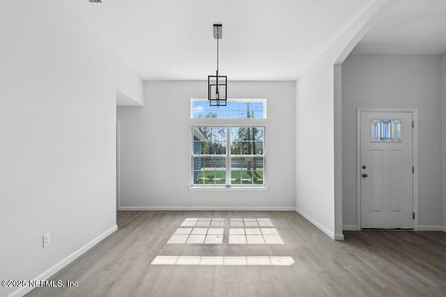 7830 Smart Ave, Jacksonville, FL 32219 - unfurnished dining area featuring wood finished floors, baseboards, and arched walkways