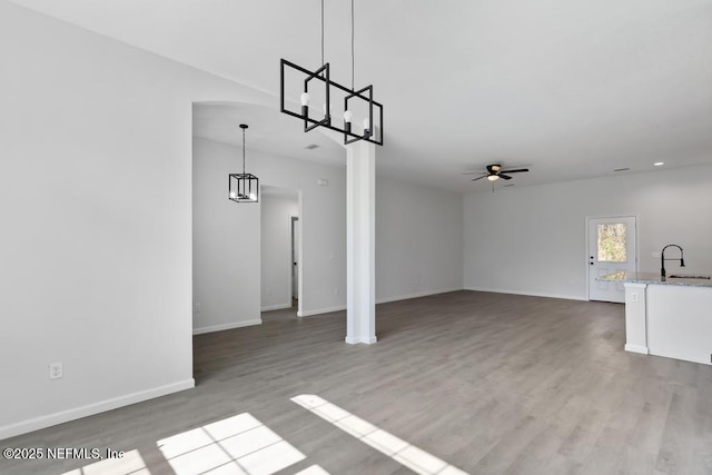 7830 Smart Ave, Jacksonville, FL 32219 - unfurnished living room with a ceiling fan, wood finished floors, a chandelier, baseboards, and recessed lighting