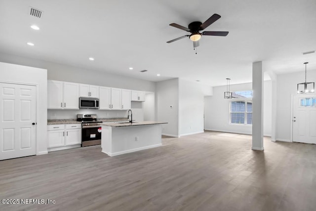 7830 Smart Ave, Jacksonville, FL 32219 - kitchen featuring stainless steel appliances, a sink, baseboards, white cabinetry, and open floor plan