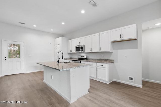 7830 Smart Ave, Jacksonville, FL 32219 - kitchen featuring appliances with stainless steel finishes, a sink, baseboards, white cabinets, and light wood-style flooring