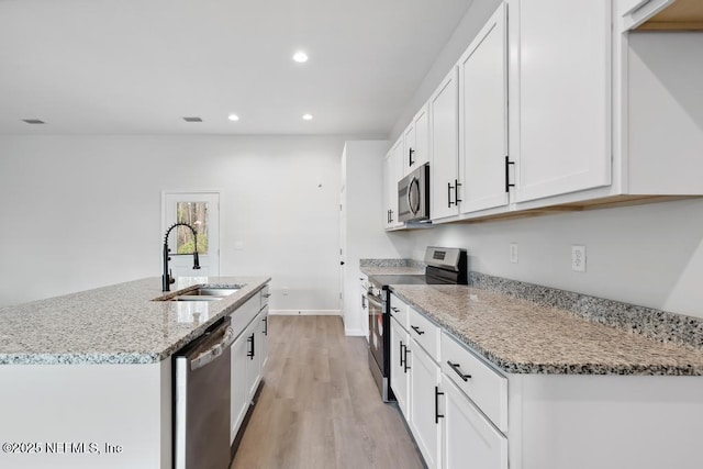 7830 Smart Ave, Jacksonville, FL 32219 - kitchen with stainless steel appliances, a sink, recessed lighting, light wood-type flooring, and light stone counters