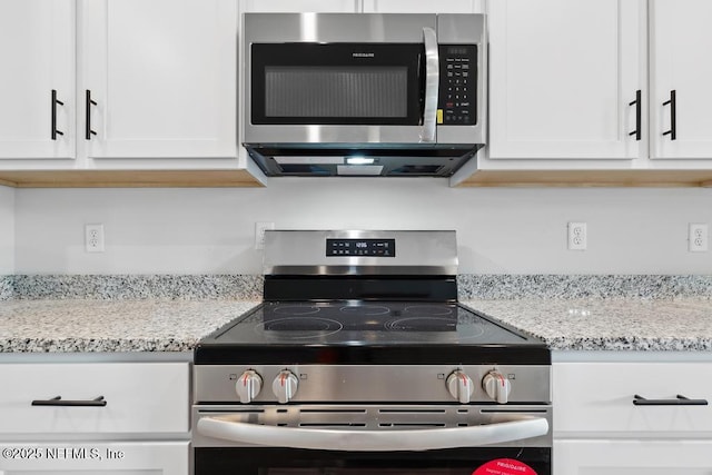 7830 Smart Ave, Jacksonville, FL 32219 - kitchen with appliances with stainless steel finishes, white cabinets, and light stone countertops
