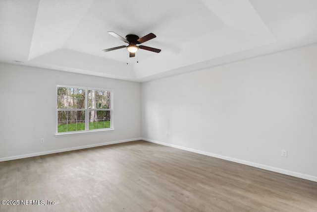 7830 Smart Ave, Jacksonville, FL 32219 - spare room featuring a tray ceiling, ceiling fan, wood finished floors, and baseboards