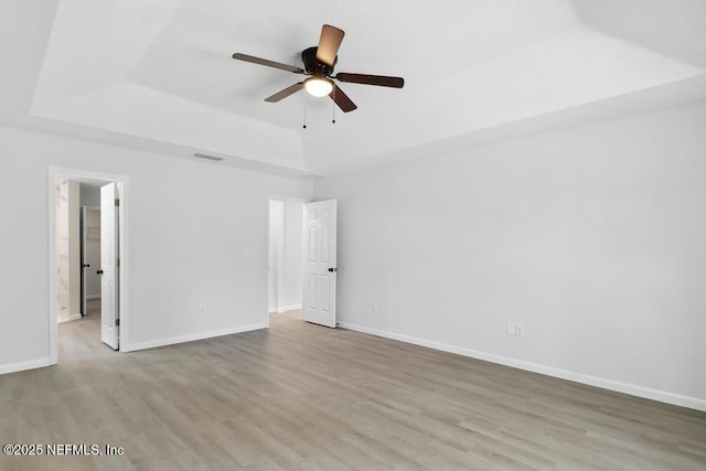 7830 Smart Ave, Jacksonville, FL 32219 - spare room with wood finished floors, a tray ceiling, a ceiling fan, and baseboards