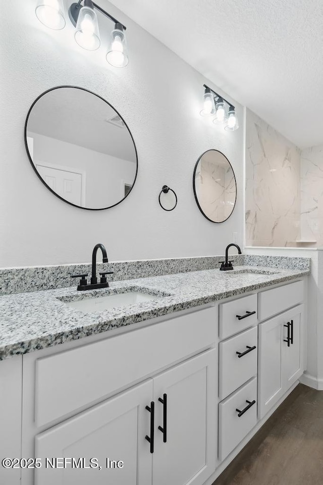 7830 Smart Ave, Jacksonville, FL 32219 - full bath featuring double vanity, a textured ceiling, and wood finished floors