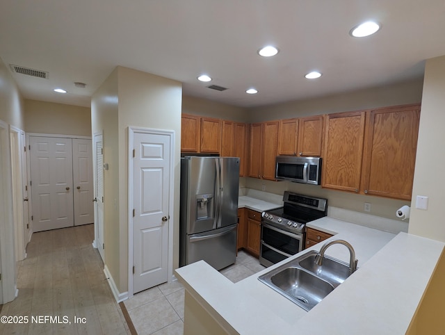 12301 Kernan Forest Blvd Unit 508, Jacksonville, FL 32225 - kitchen featuring appliances with stainless steel finishes, a sink, brown cabinets, light countertops, and recessed lighting