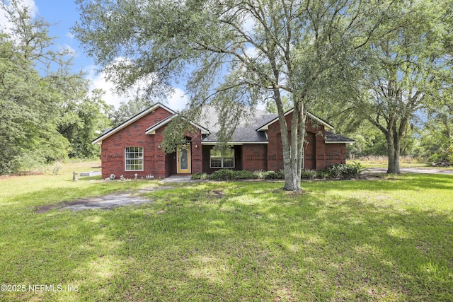 3784 Charles Green Rd, Hilliard, FL 32046 - view of front of house featuring a front yard, brick siding, and a shingled roof