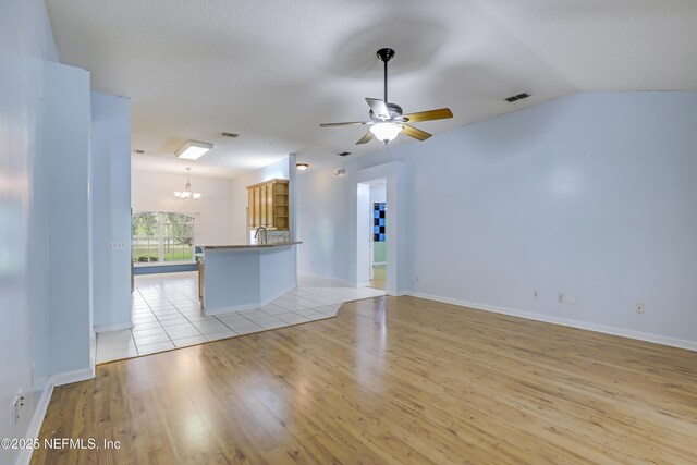 3784 Charles Green Rd, Hilliard, FL 32046 - unfurnished living room featuring a chandelier, light wood-type flooring, a ceiling fan, baseboards, and a sink