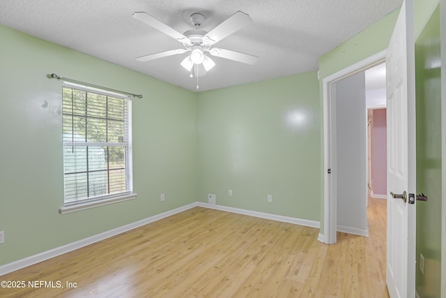 3784 Charles Green Rd, Hilliard, FL 32046 - empty room with light wood finished floors, a ceiling fan, baseboards, and a textured ceiling