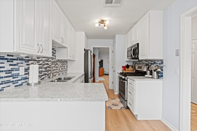 12422 Berry Patch Way, Jacksonville, FL 32225 - kitchen featuring appliances with stainless steel finishes, a sink, light wood-type flooring, and white cabinets