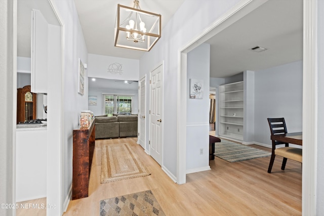 12422 Berry Patch Way, Jacksonville, FL 32225 - hall featuring wood finished floors, a chandelier, and baseboards