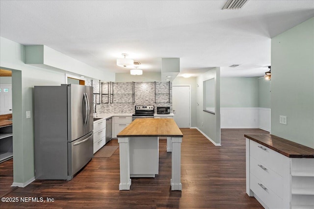 1344 Degrove Rd, Saint Johns, FL 32259 - kitchen featuring appliances with stainless steel finishes, wooden counters, dark wood-style floors, a ceiling fan, and white cabinetry