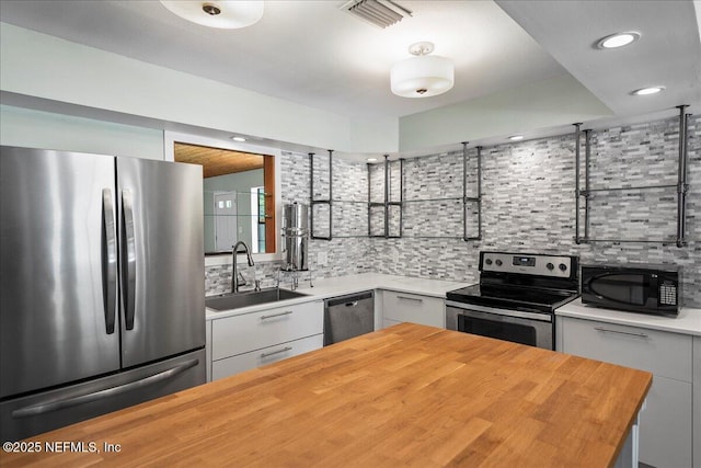 1344 Degrove Rd, Saint Johns, FL 32259 - kitchen with appliances with stainless steel finishes, wooden counters, a sink, tasteful backsplash, and modern cabinets