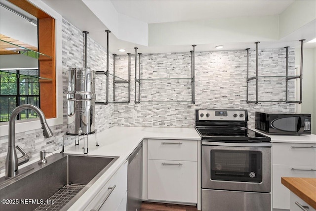 1344 Degrove Rd, Saint Johns, FL 32259 - kitchen featuring appliances with stainless steel finishes, a sink, decorative backsplash, white cabinetry, and light countertops