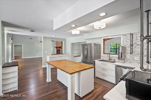 1344 Degrove Rd, Saint Johns, FL 32259 - kitchen with wooden counters, stainless steel appliances, a sink, white cabinets, and dark wood-style floors