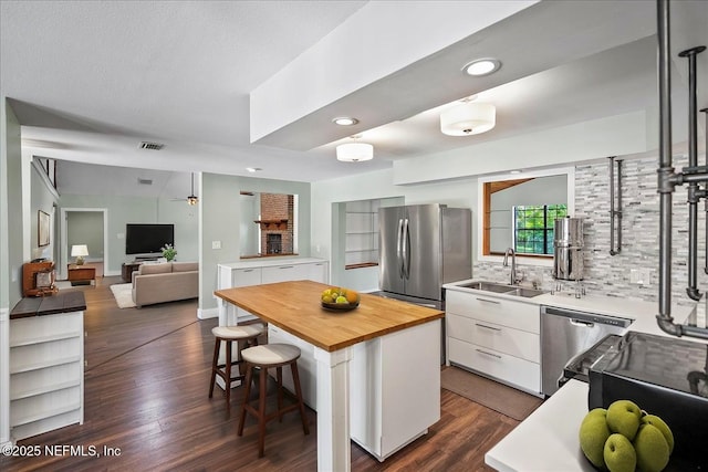 1344 Degrove Rd, Saint Johns, FL 32259 - kitchen with appliances with stainless steel finishes, wood counters, a sink, white cabinets, and a kitchen bar