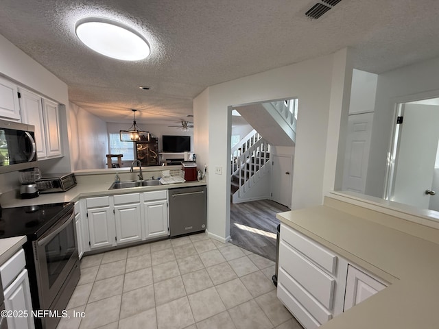 200 Spindrift Ln, Neptune Beach, FL 32266 - kitchen featuring stainless steel appliances, a sink, a textured ceiling, light countertops, and light tile patterned flooring