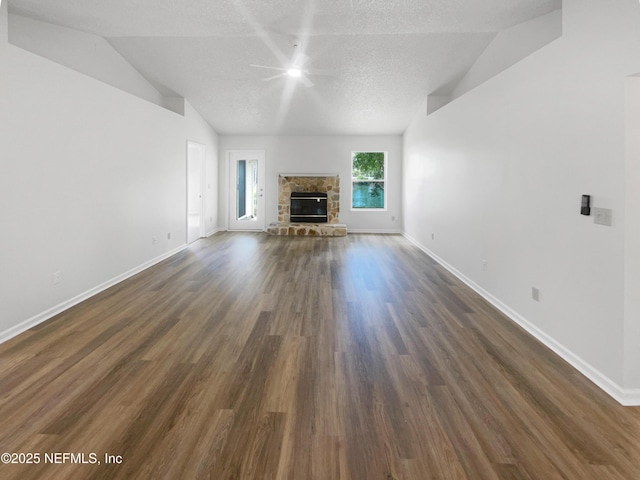 12011 Cobblestone Forest Cir S, Jacksonville, FL 32225 - unfurnished living room with lofted ceiling, ceiling fan, dark wood-type flooring, baseboards, and a stone fireplace
