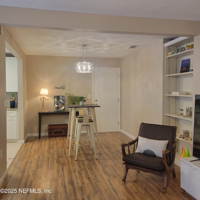 5201 Atlantic Blvd Unit 68, Jacksonville, FL 32207 - sitting room featuring light wood finished floors, baseboards, a chandelier, and built in features