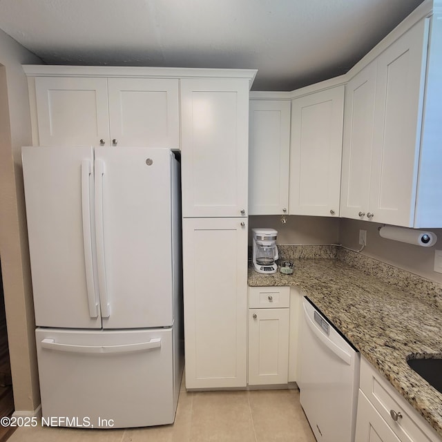 5201 Atlantic Blvd Unit 68, Jacksonville, FL 32207 - kitchen with white appliances, light tile patterned floors, white cabinetry, and light stone counters