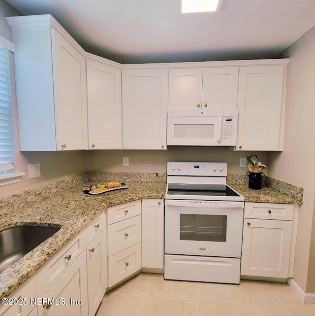 5201 Atlantic Blvd Unit 68, Jacksonville, FL 32207 - kitchen with white appliances, light tile patterned floors, white cabinetry, and light stone counters