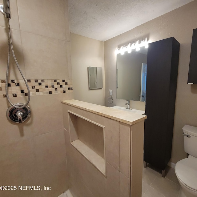 5201 Atlantic Blvd Unit 68, Jacksonville, FL 32207 - bathroom featuring toilet, a textured ceiling, tile patterned flooring, a tile shower, and vanity