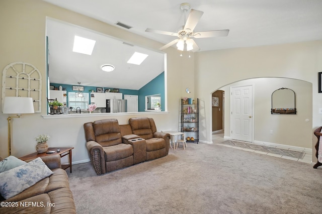 1537 Elmar Rd, Jacksonville, FL 32226 - carpeted living room with a skylight, arched walkways, ceiling fan, vaulted ceiling, and baseboards