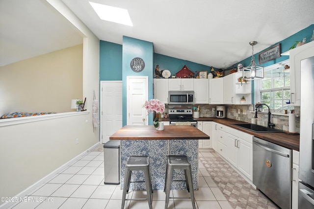 1537 Elmar Rd, Jacksonville, FL 32226 - kitchen featuring wooden counters, stainless steel appliances, a sink, vaulted ceiling, and backsplash