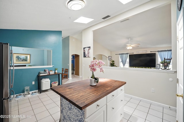 1537 Elmar Rd, Jacksonville, FL 32226 - kitchen with butcher block counters, freestanding refrigerator, arched walkways, light tile patterned floors, and lofted ceiling